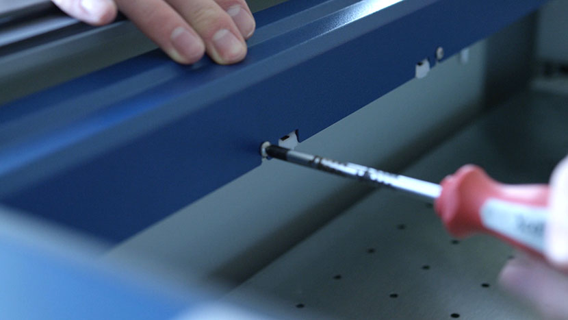 Loosening a screw on the back of the X-Axis Assembly.