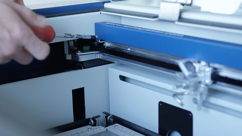 Loosening a screw on the front of the X-Axis Assembly.