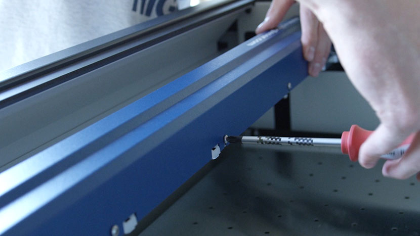 Tightening a screw on the back of the X-Axis Assembly.