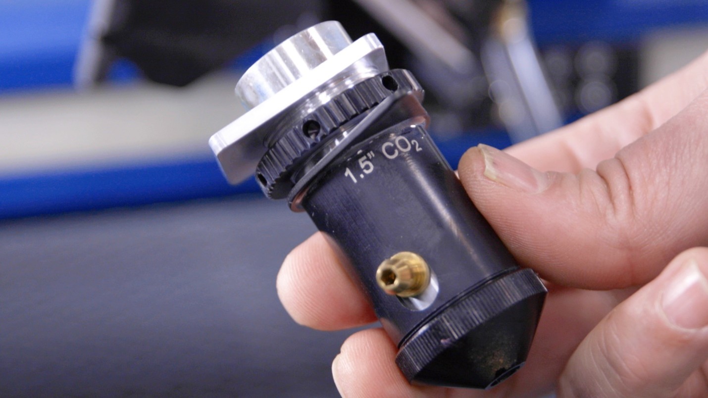 A hand holding a small black and silver device